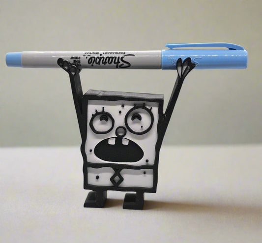 Funny black and white Doodle Bob style figurine pencil holder holding a blue Sharpie marker across raised arms