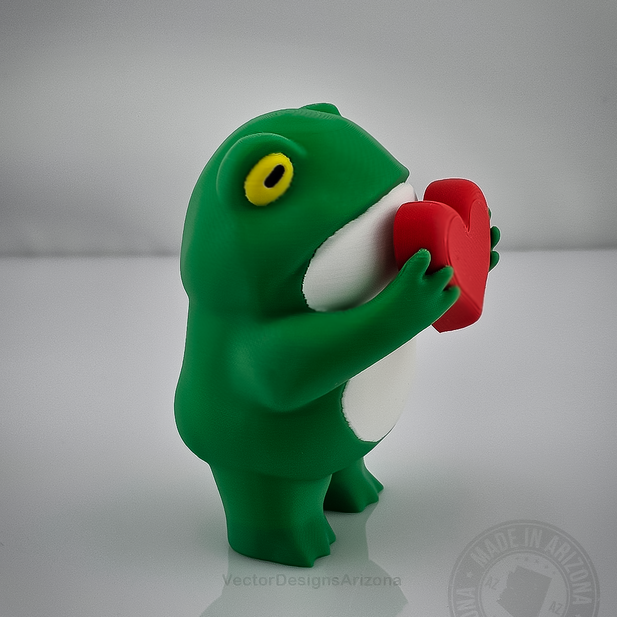 Love Frog 3D printed figurine with yellow eyes, white belly, and red heart.