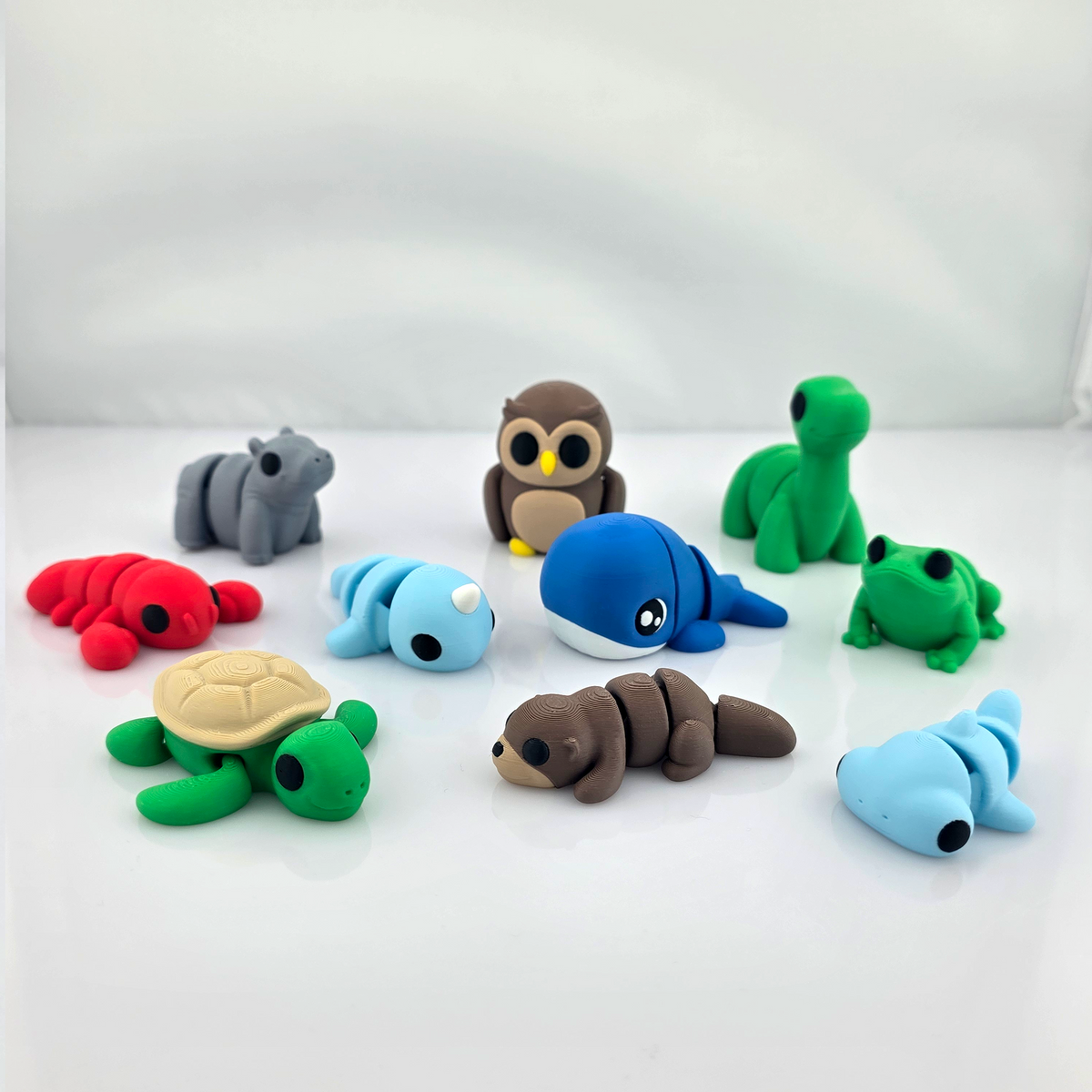 Group of colorful mini flexy animal toys arranged on clean white background.