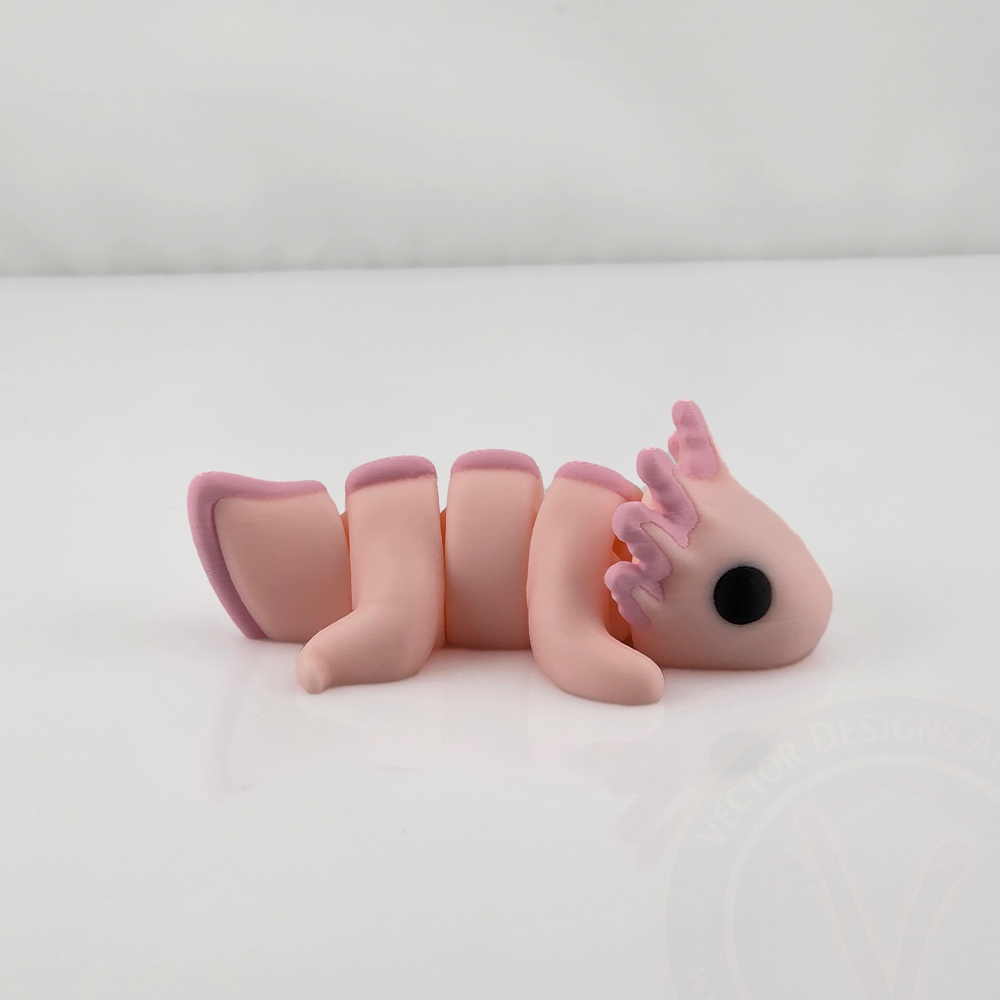 Pink mini flexy axolotl toy lying on white background, side view.