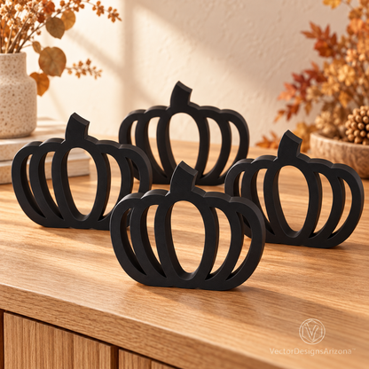Four matte black minimalist 3D-printed pumpkins with open-frame designs, styled on a wood console with warm fall decor.