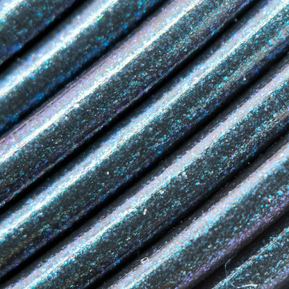 Cookiecad Dark Magic PETG filament close-up – green-blue-purple iridescent shimmer on black base
