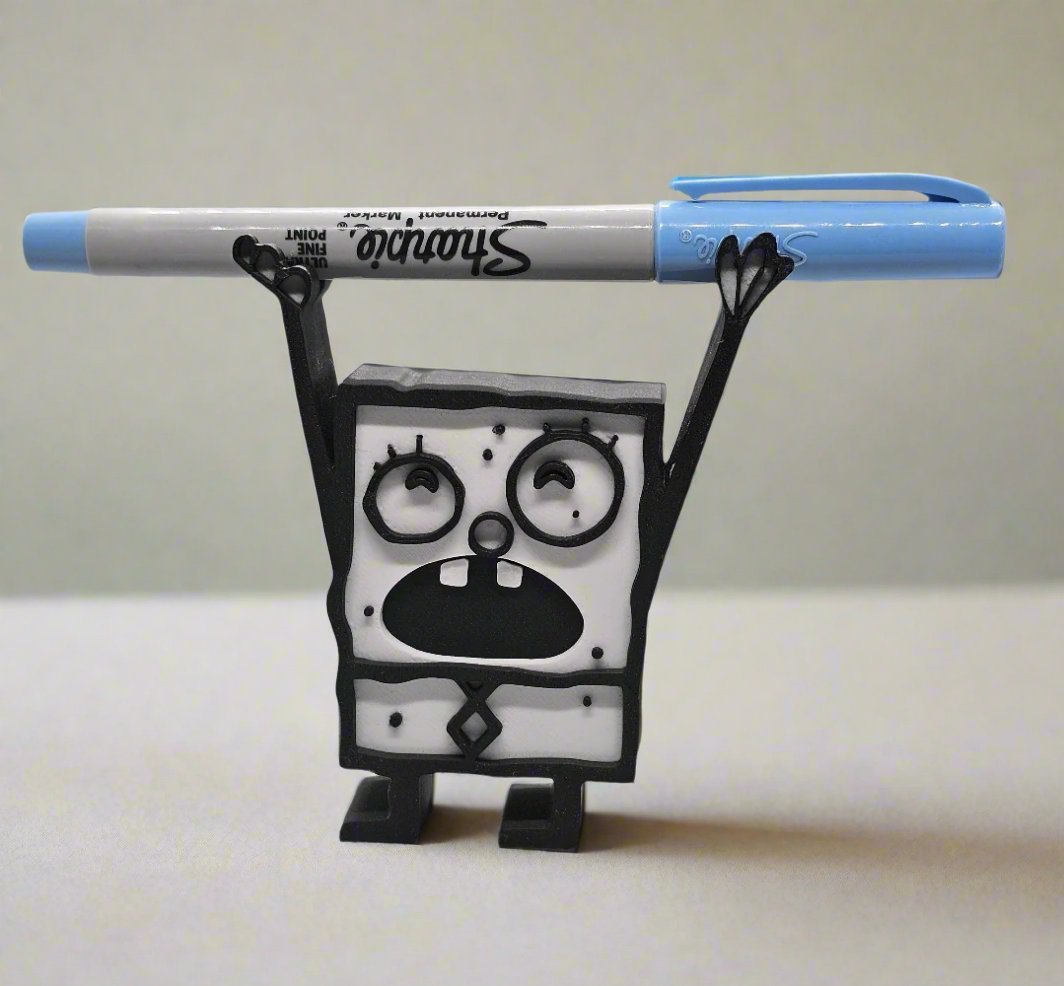 Funny black and white Doodle Bob style figurine pencil holder holding a blue Sharpie marker across raised arms