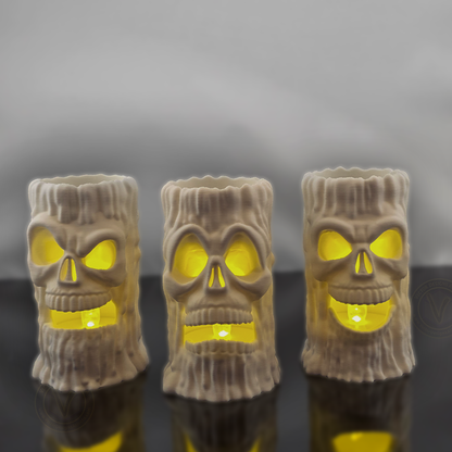 Three 3D printed skull candle holders by VectorDesignsArizona with LED lights placed inside the base, lighting up the eyes and mouth for dramatic haunted house decor.