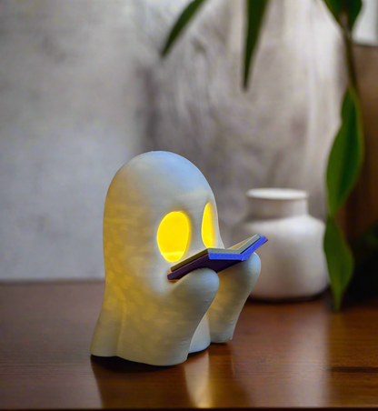 3D printed ghost figure holding glow‑in‑the‑dark book