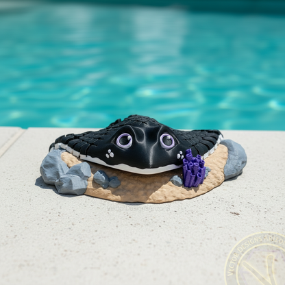 Black 3D printed stingray sitting on a custom sand and coral display stand next to a pool, created by Vector Designs Arizona.