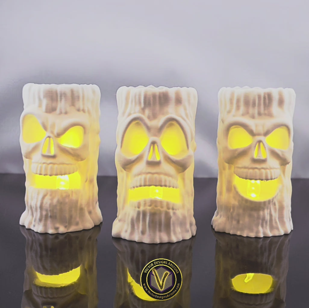 Three 3D printed skull candle holders by VectorDesignsArizona with LED lights placed inside the base, lighting up the eyes and mouth for dramatic haunted house decor.