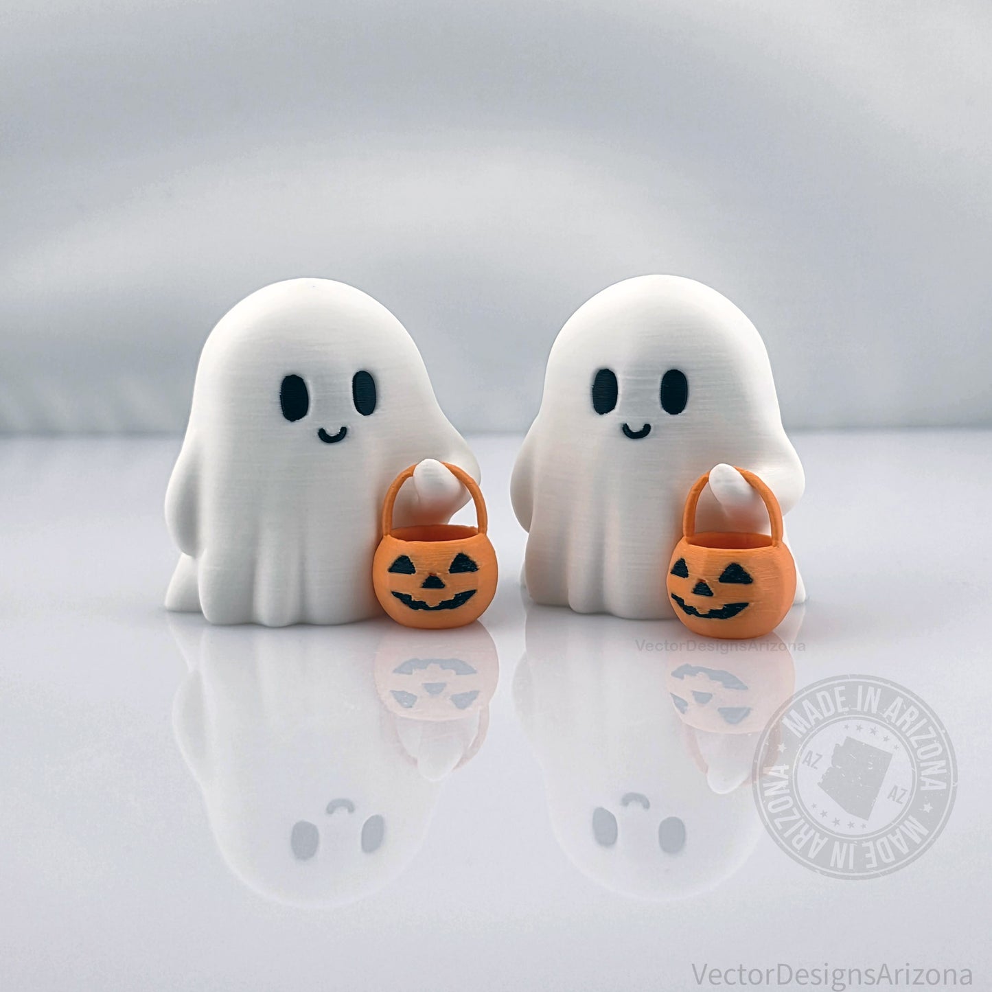 Pair of tiny 3D printed Halloween ghost figurines with pumpkin buckets, eco-friendly PLA decor for spooky fall displays.