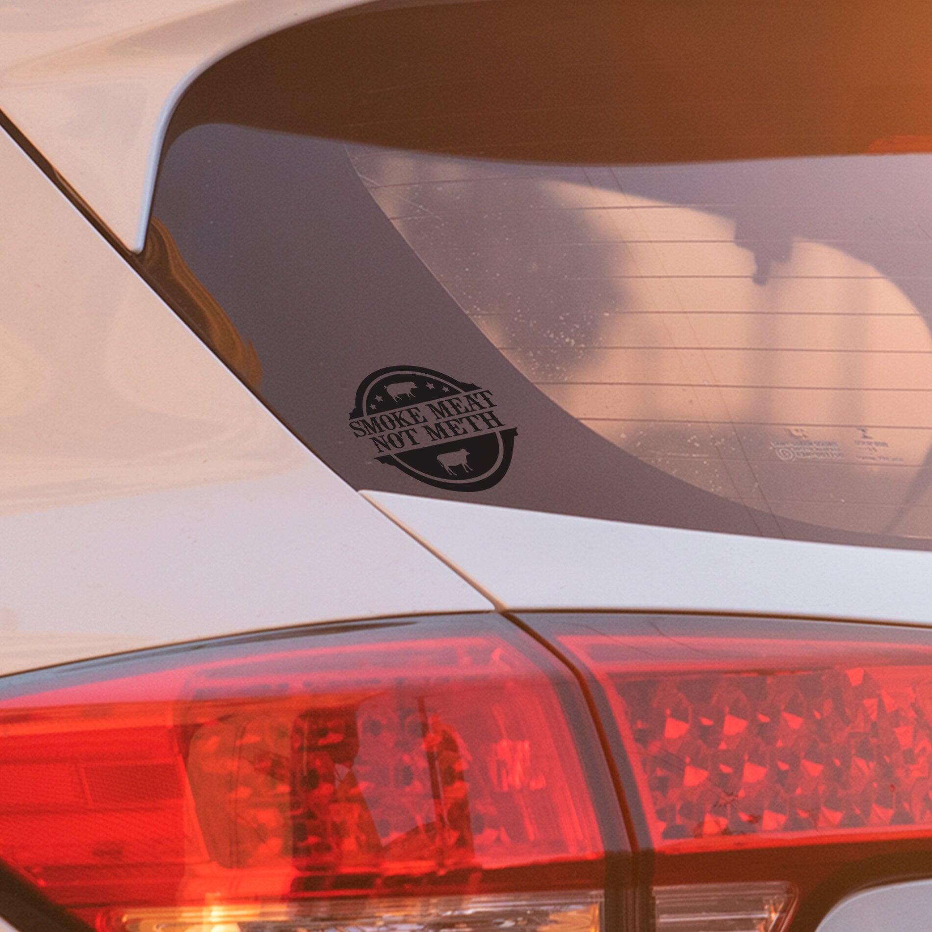 Funny black vinyl decal saying ‘Smoke Meat Not Meth’ applied to car window, weather-resistant vehicle sticker.