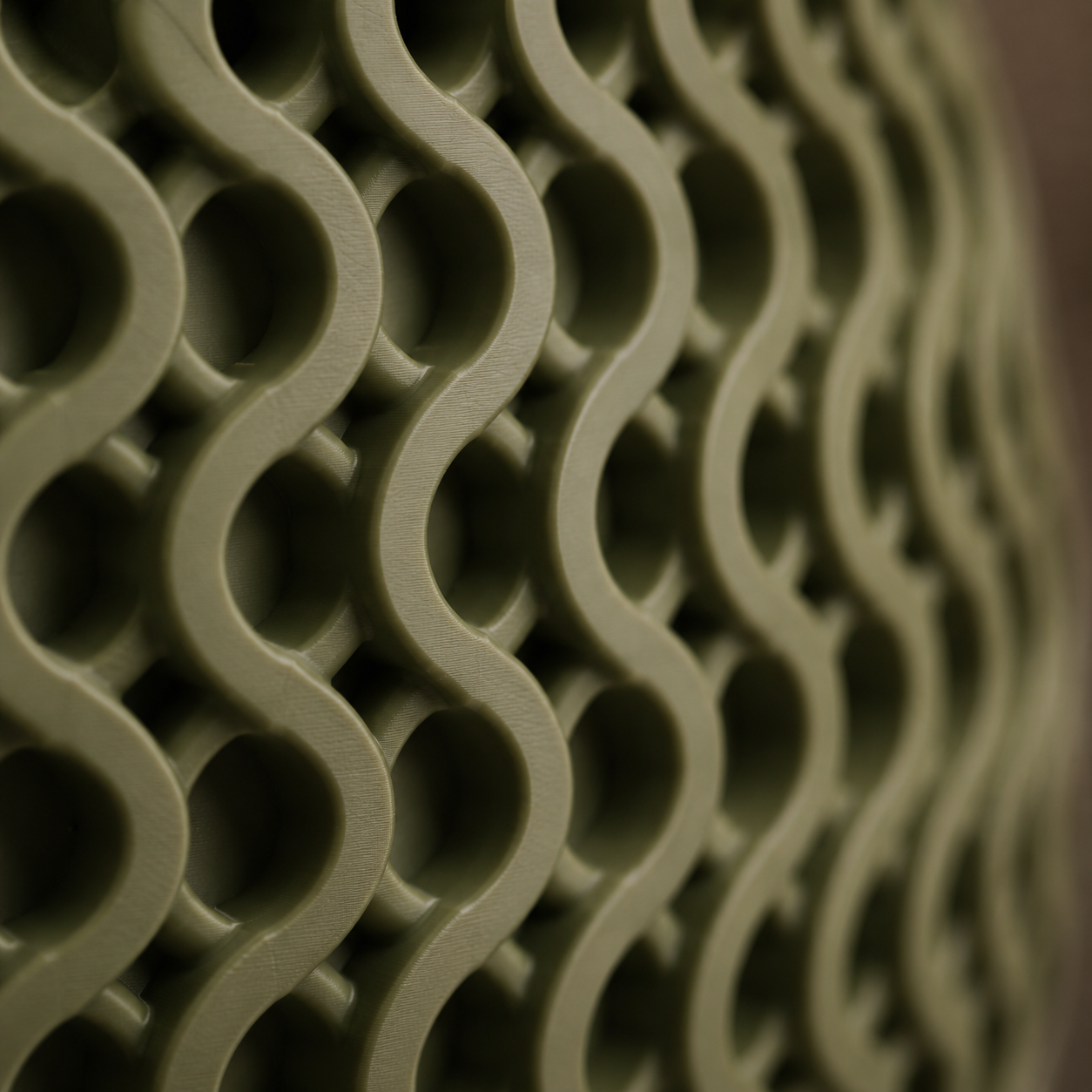 Side view of the olive green Solara Wave Planter with latte brown sculpted drip tray and modern wave texture.