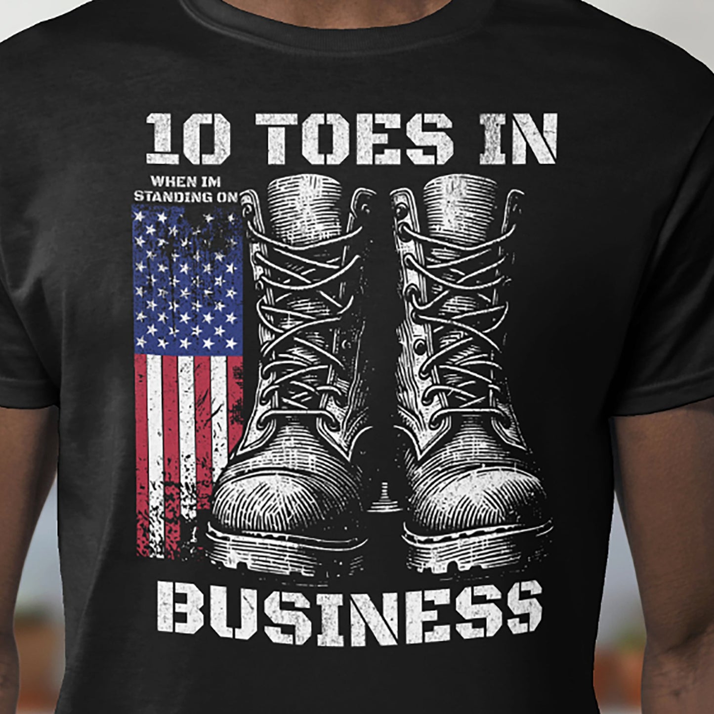 Black patriotic T-shirt with combat boots and American flag graphic on chest.