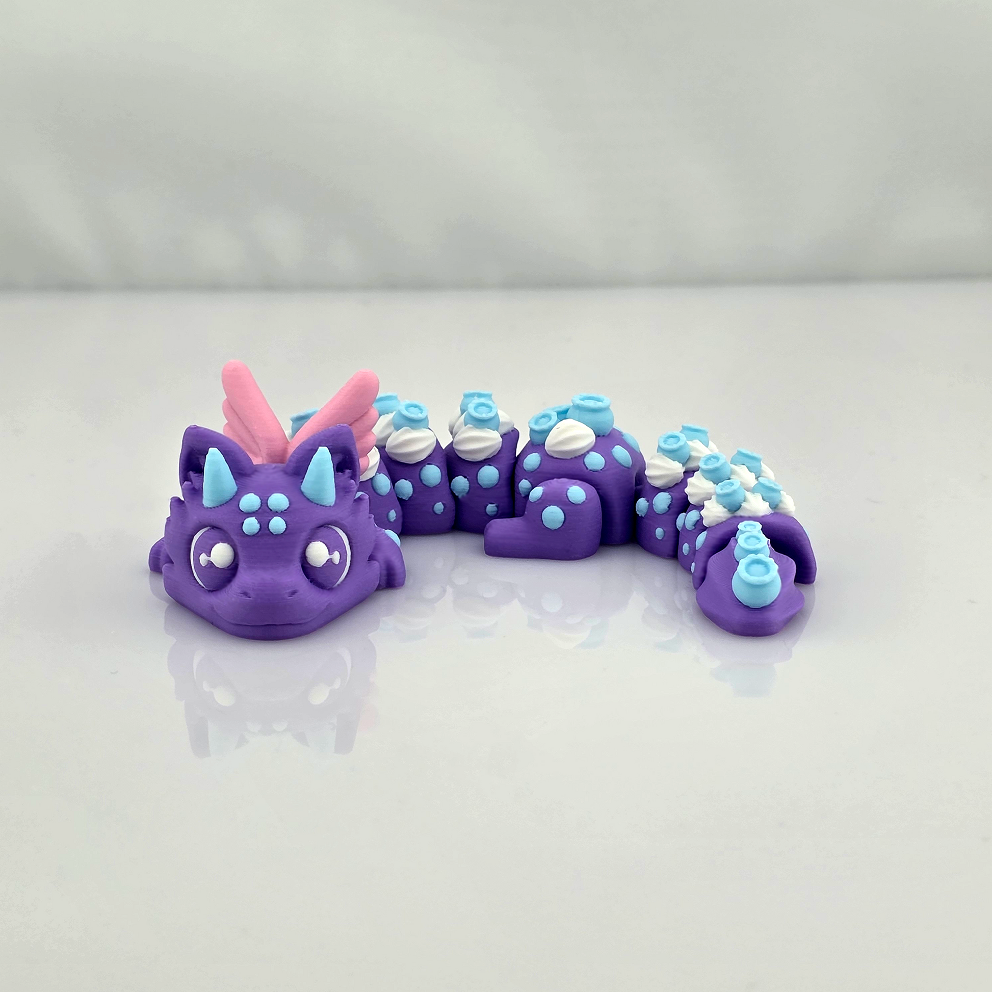 Front view of a purple Blueberry Dragon 3D printed flexi fidget toy on a clean white background.