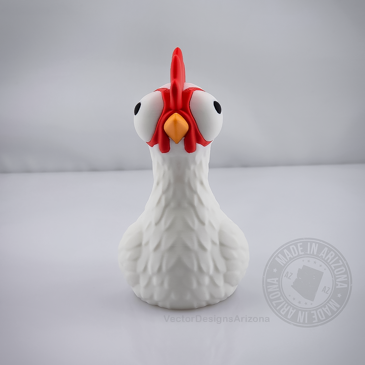 Front view goofy chicken figurine with big eyes on light grey studio background.