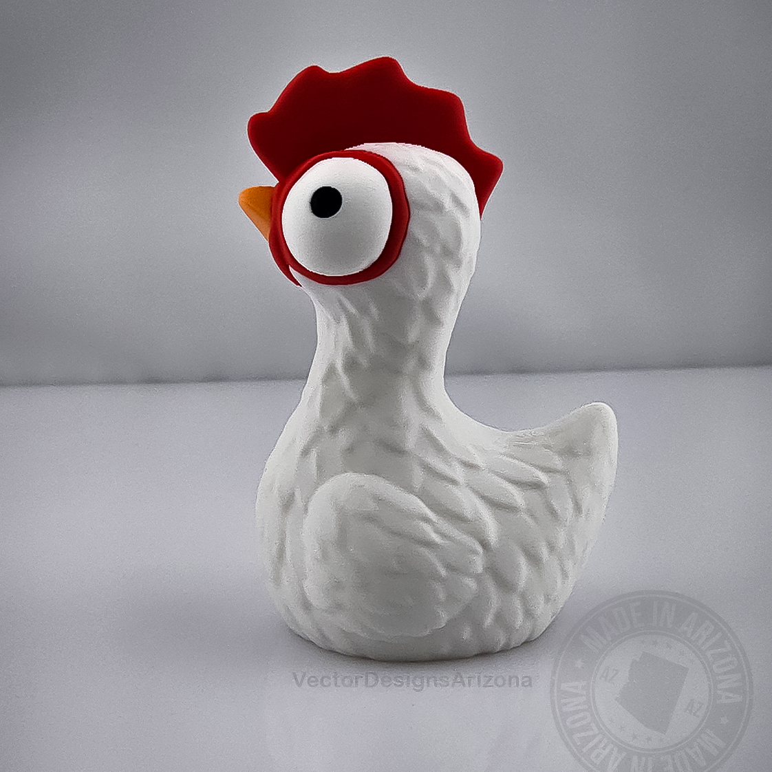 Side view goofy chicken figurine with red comb on light grey background.