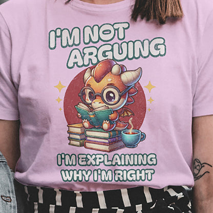 Close-up of I’m Not Arguing dragon reading book graphic on pink T-shirt.