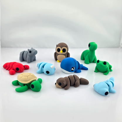 Group of colorful mini flexy animal toys arranged on clean white background.