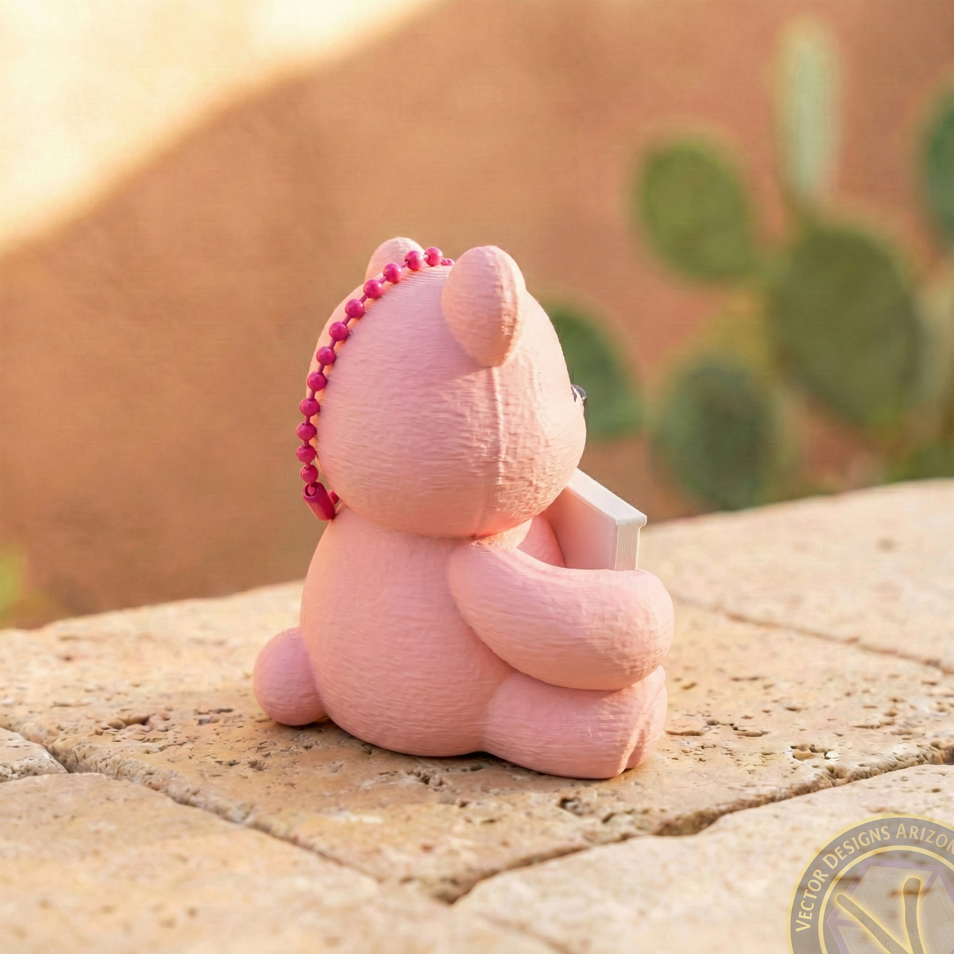 Back view of a pink 3D printed bear bag charm showing the sturdy loop for keychain or zipper attachment.