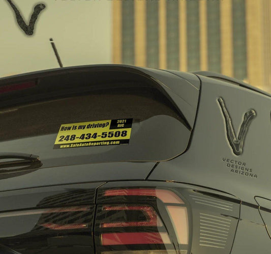 Rick Roll yellow “how is my driving” bumper sticker on rear car window.