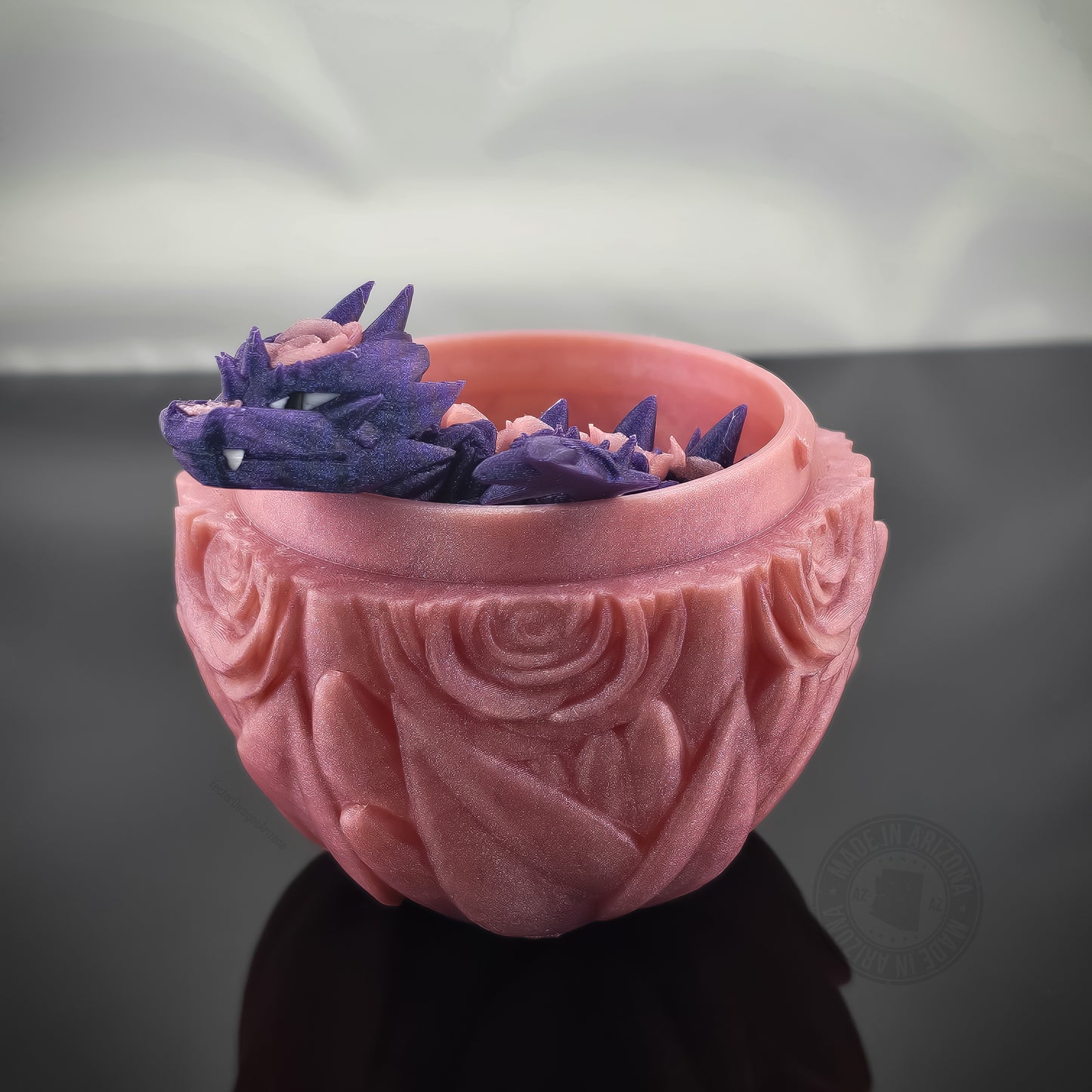 Purple rose dragon flexi figurine curled inside pink rose-textured egg on glossy surface.