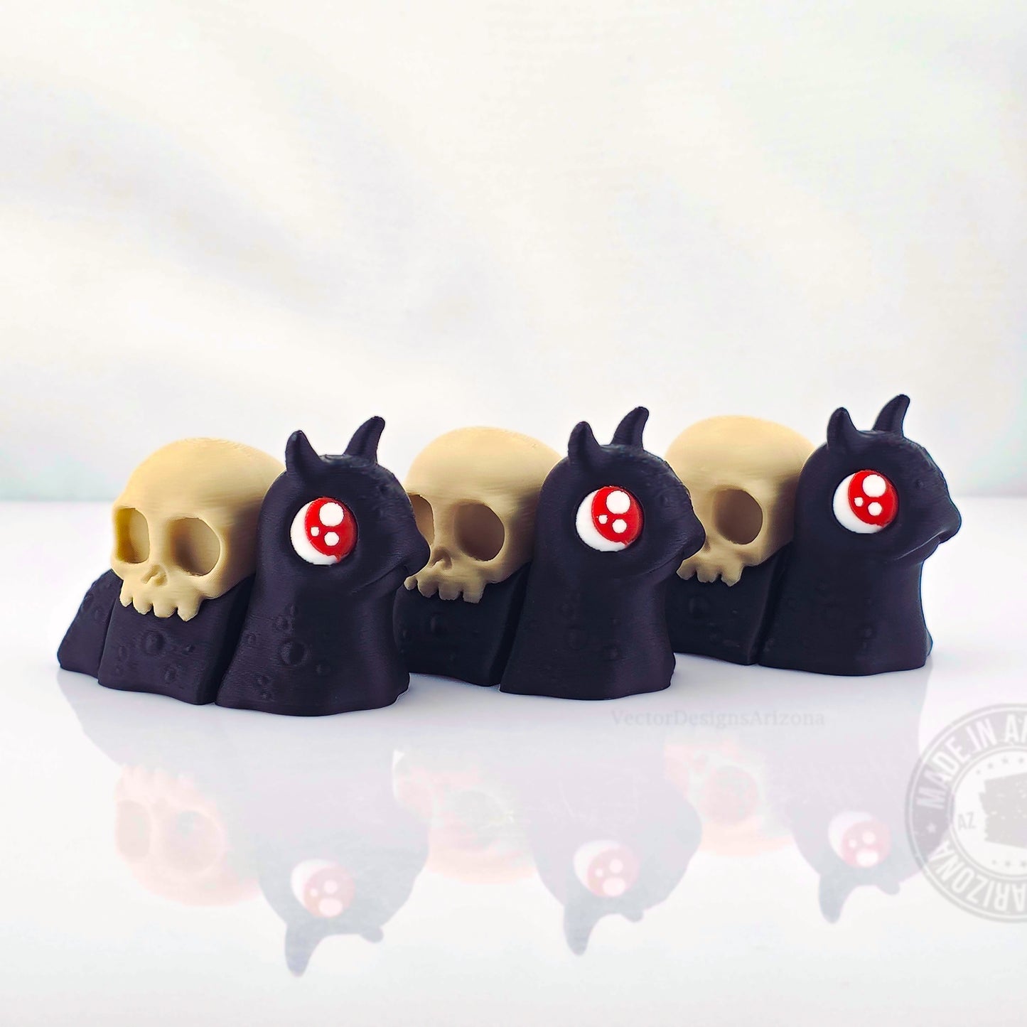 Row of spooky black snails with skull shells on white reflective background.