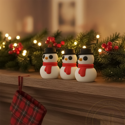 Three tiny winter snowmen figurines on Christmas mantel with garland and lights.