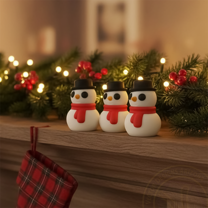 Three tiny winter snowmen figurines on Christmas mantel with garland and lights.