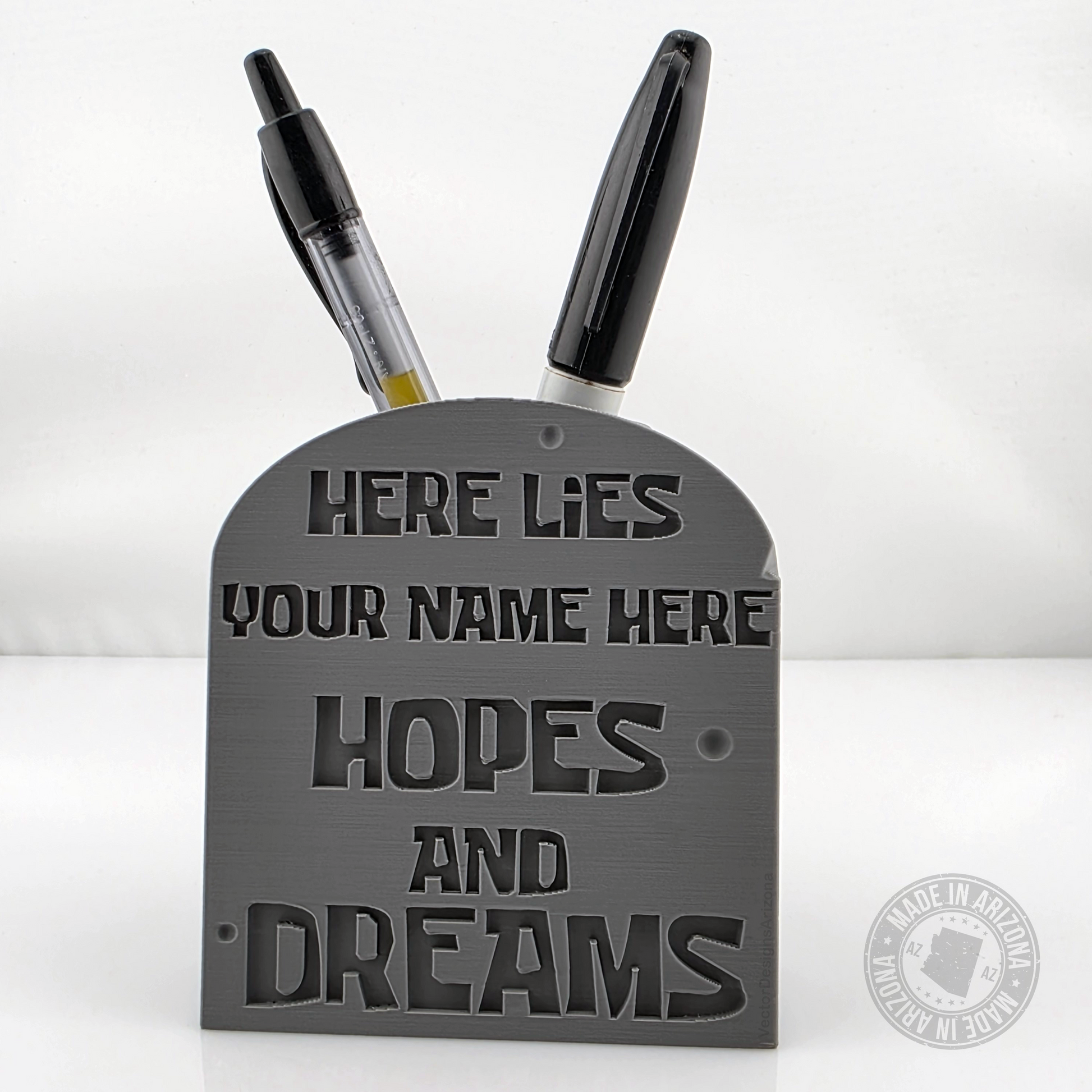 Gray personalized tombstone desk pen holder with engraved hopes and dreams text and pens.