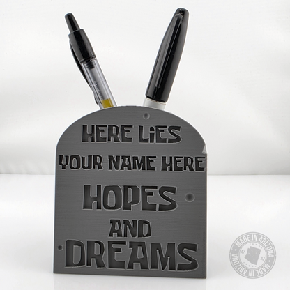 Gray personalized tombstone desk pen holder with engraved hopes and dreams text and pens.